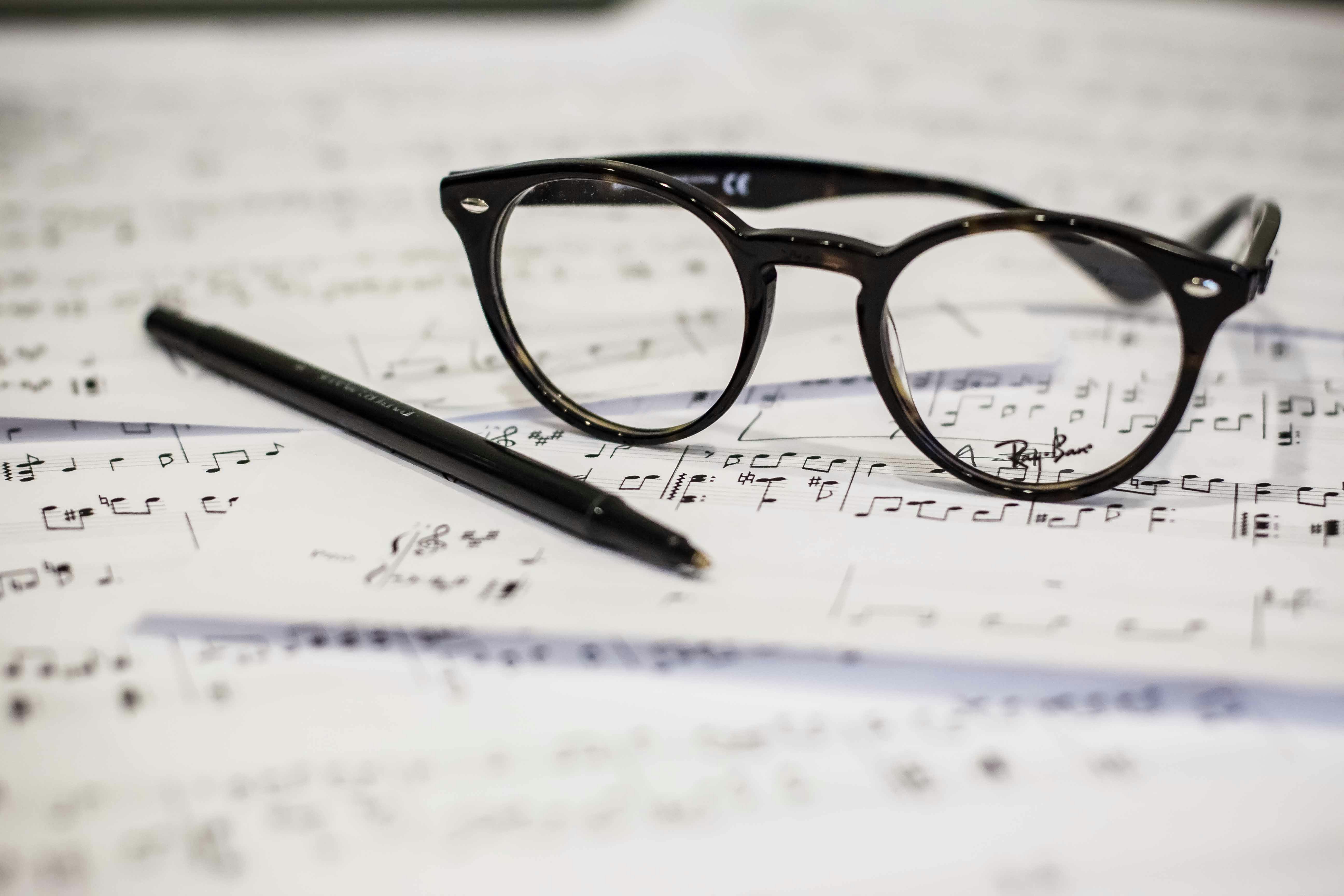 black-framed glasses and a pen