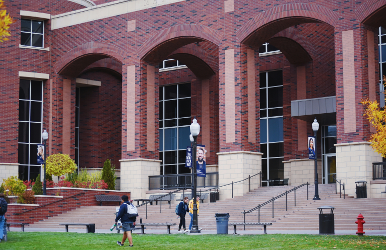 college students walking out of a school building
