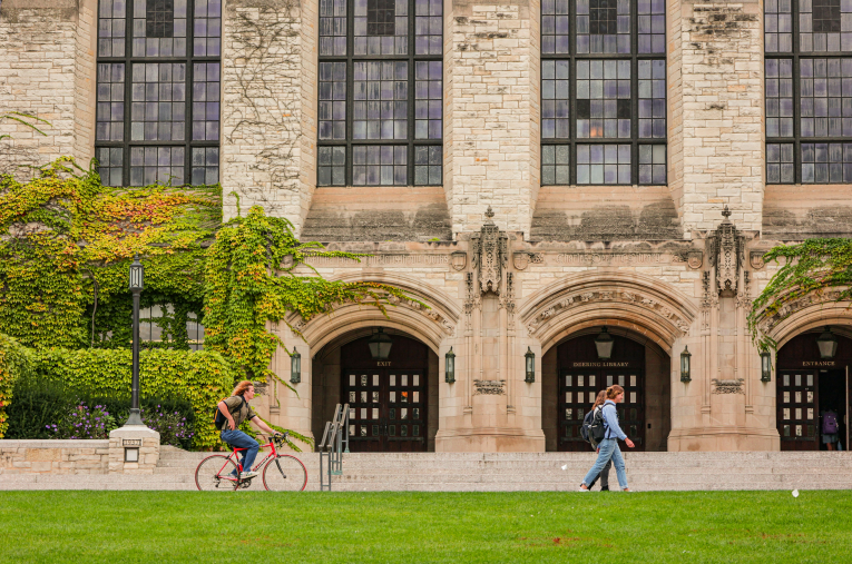 a couple of people walking in front of a school building