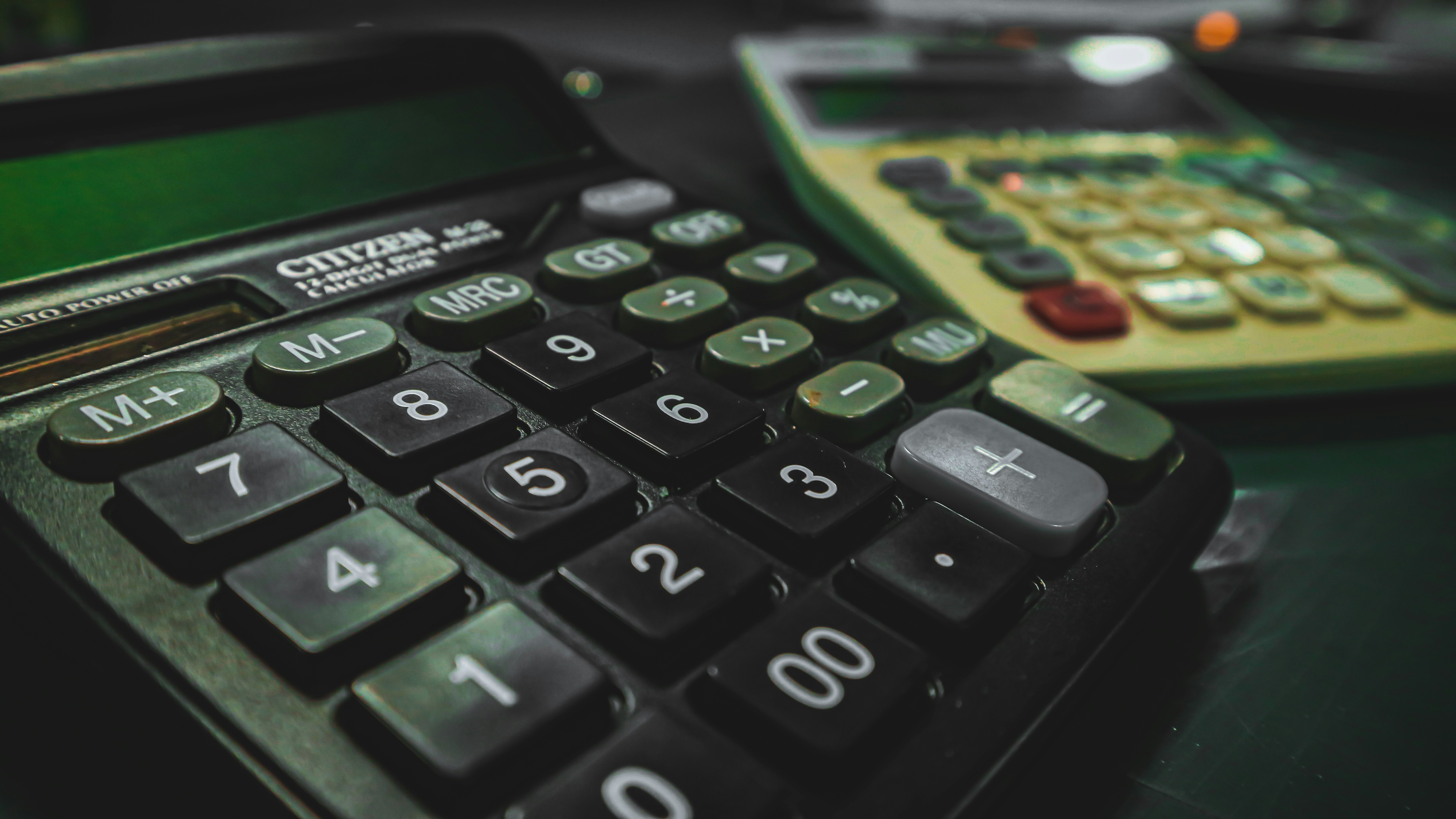a calculator on a table besides another calculator