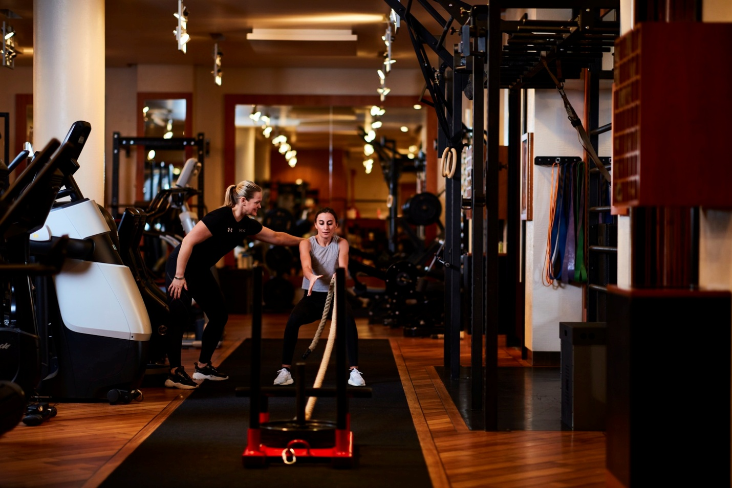 a woman coach help another woman work out