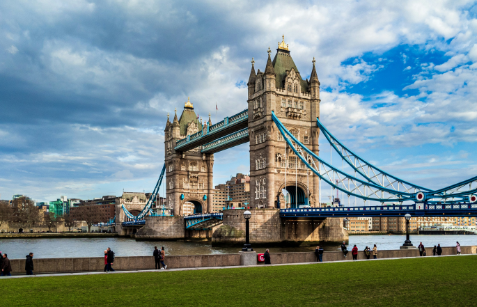 people walking along the riverside of London Bridge in London