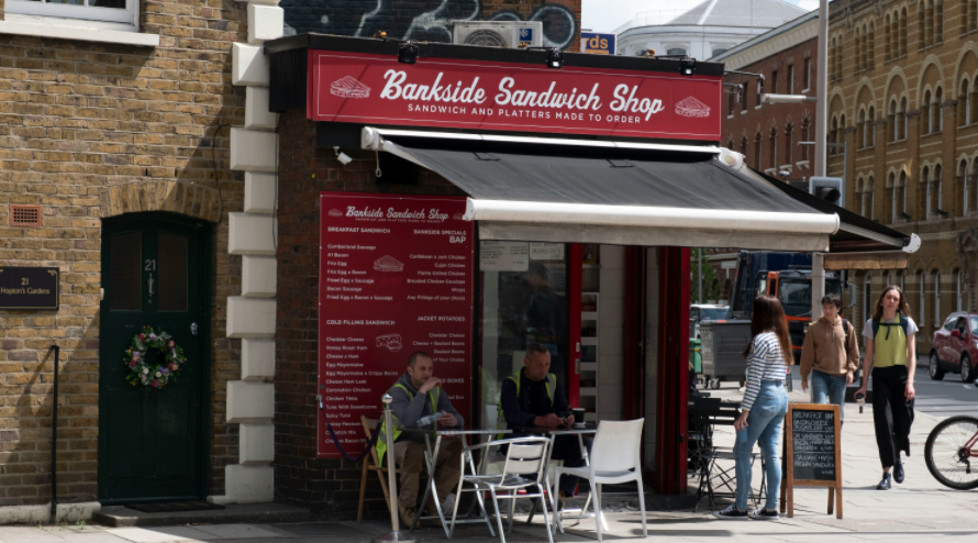 a group of people standing outside of a restaurant