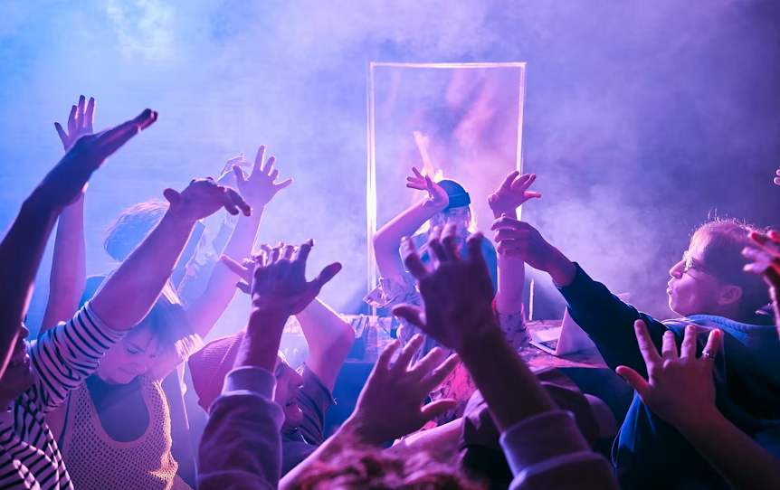 a group of people with hand up in a club