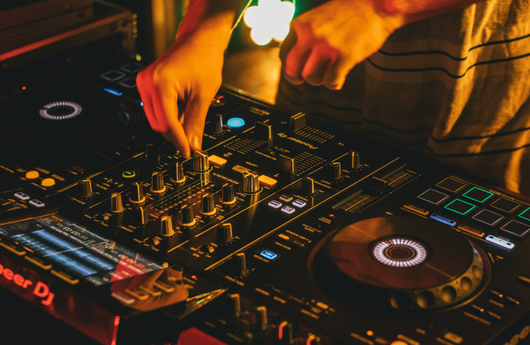person playing DJ mixer in a club