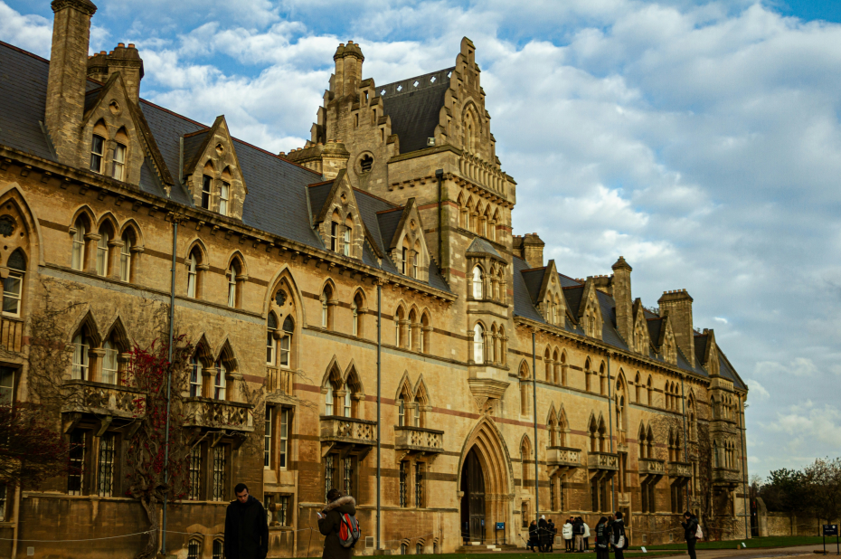 a group of people standing in front of a building in oxford university