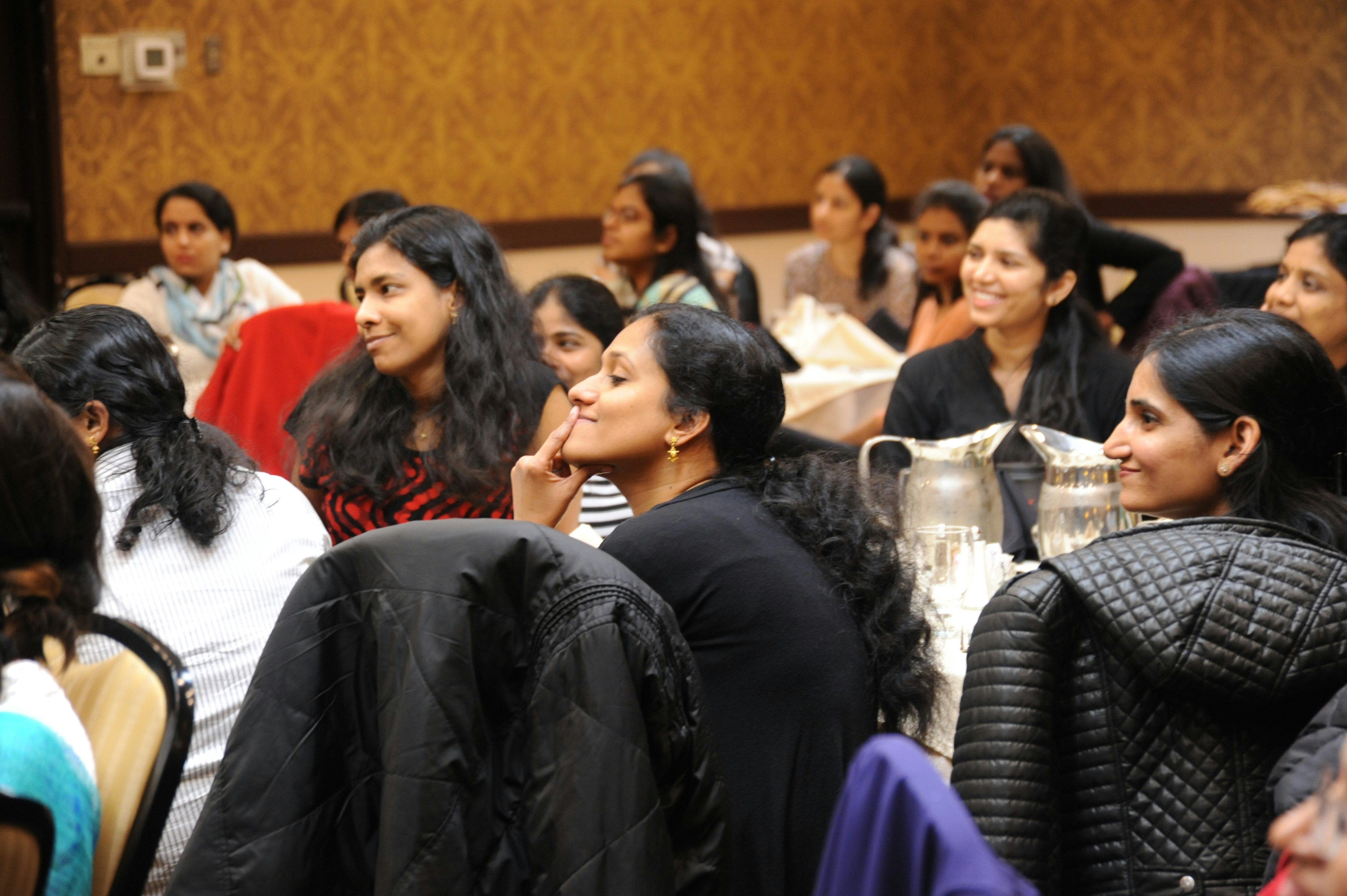a group of Indian women sitting on a chair while listening