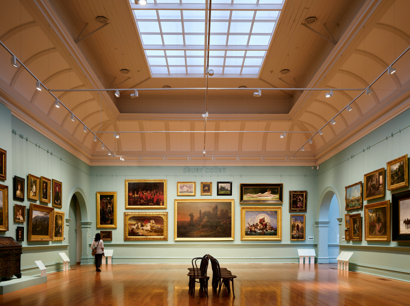 people visiting a room filled with paintings